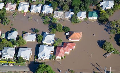 aerial view of the rooves of houses in brown floodwater